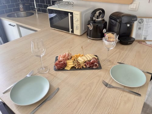 Table élégamment dressée chez Chez Mary Studios avec plateau de charcuterie, verres de vin et appareils de cuisine modernes