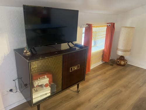 Retro 1970s-themed apartment at Chez Mary Studios Gannat with vintage TV stand, wood flooring, and period décor