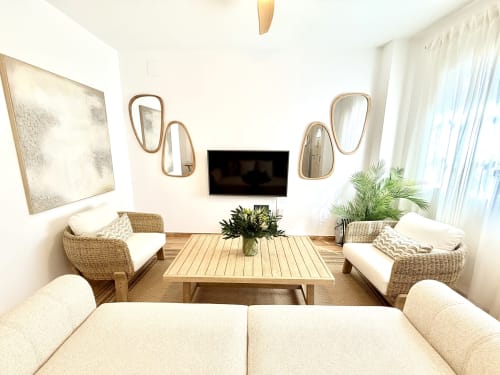 Moderna sala de estar en cabaña frente al mar en Málaga con asientos de mimbre, mesa de madera y vistas al océano