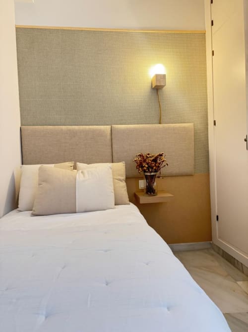 Dormitorio moderno en apartamento Cathedral Deluxe, centro histórico de Málaga, con cabecera tapizada gris, ropa de cama blanca y
