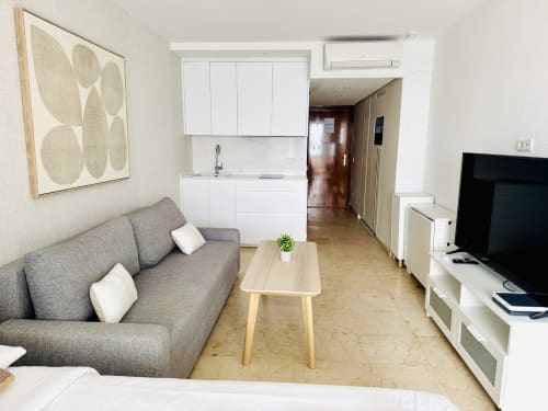 Apartamento moderno en Torremolinos con sofá gris, cocina americana y vistas al mar en Sinese Design Homes