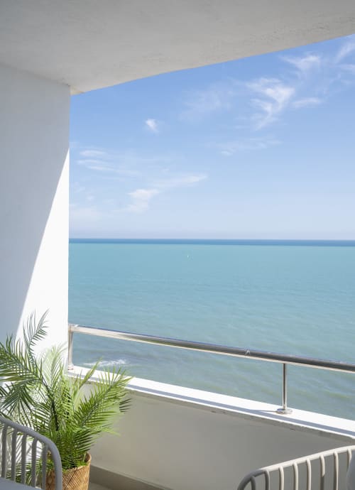 Balcón moderno con vista al mar en ROCA Beach Torremolinos, elemento arquitectónico blanco, aguas turquesas del Mediterráneo, palma