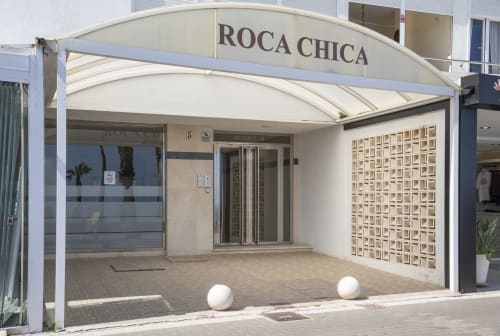 Fachada de ROCA CHICA en Torremolinos con toldo blanco y entrada moderna, cerca de apartamentos de playa