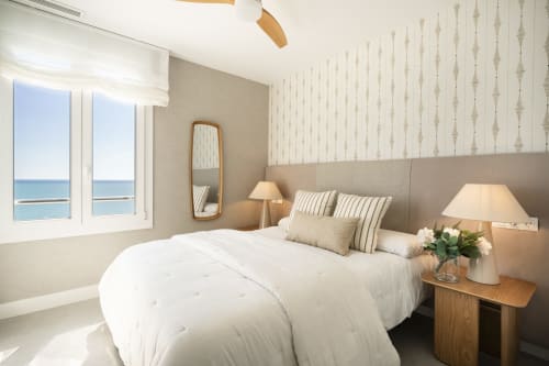 Luminosa habitación con vistas al mar en ROCA Beach Torremolinos Premium, ropa de cama blanca, cabecero beige, espejo de madera y océano