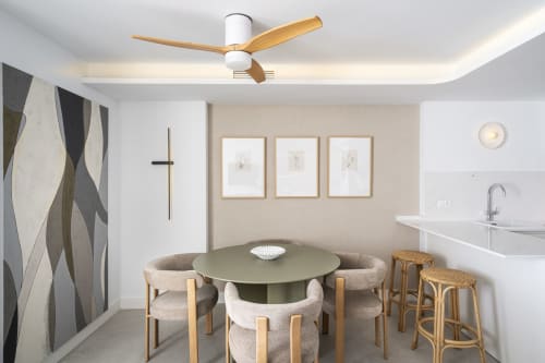 Moderna zona de comedor en apartamento premium ROCA Beach Torremolinos con mesa oliva redonda, sillas beige, taburetes de madera y