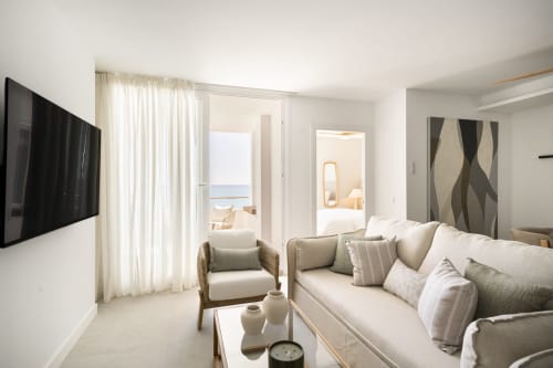 Sala de estar moderna en apartamento con vistas al mar en Torremolinos, sofá, sillón y balcón frente a la playa