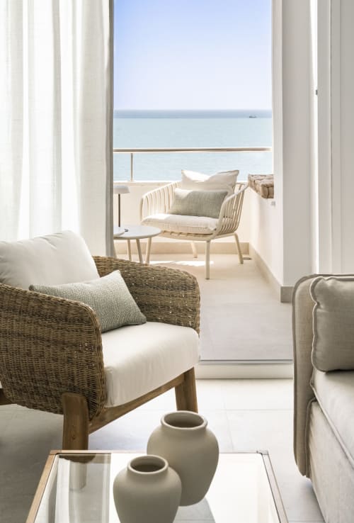 Sala de estar de apartamento frente al mar con sillas de mimbre, vistas al mar desde la terraza, Torremolinos