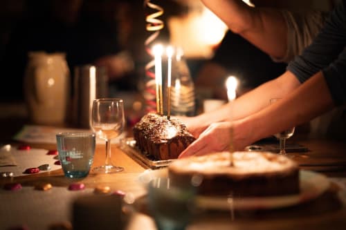 Célébration d'anniversaire à Suite L'Olive Sacrée à Cabannes avec gâteau au chocolat, bougies et table élégamment dressée