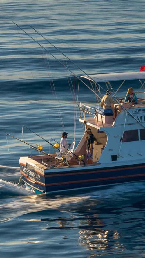 Barco de pesca Katherine B ancorado em Calheta com tripulantes e varas de pesca em águas tranquilas