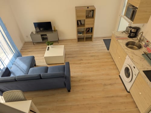 Séjour ouvert avec canapé, kitchenette, lave-linge et rangements à la Résidence des dunes, Landéda