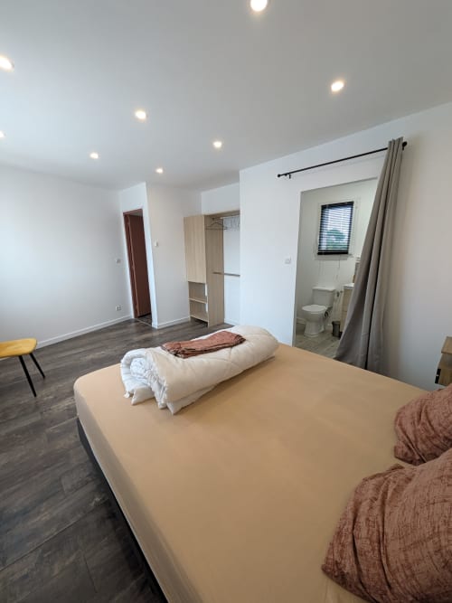 Chambre moderne de la Résidence des dunes à Landéda avec lit double, salle de bain attenante et décoration contemporaine