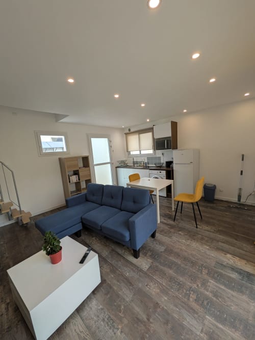 Cottage moderne ouvert à la Résidence des dunes avec canapé sectionnel bleu, cuisine équipée, coin repas jaune