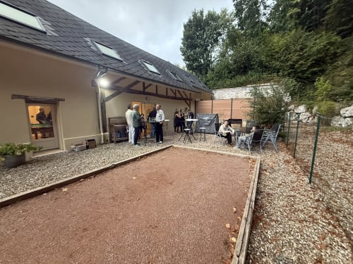 Rassemblement dans la cour des Gîtes de Flaubert à Morville-le-Héron, avec des hôtes profitant de la terrasse extérieure
