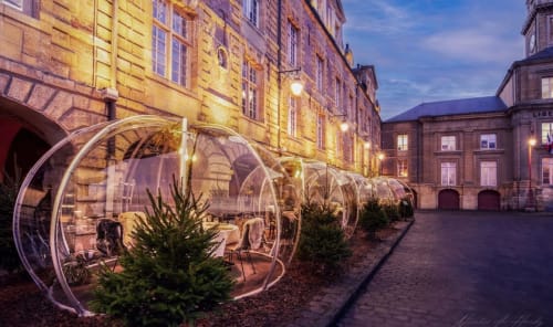 Bulles de restaurant illuminées dans la cour de l'hôtel Les séjours Ardennais à Renwez, France au crépuscule