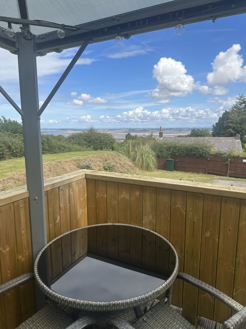 Luxury hot tub on covered deck with scenic sea views at Acorns Glamping, Holywell
