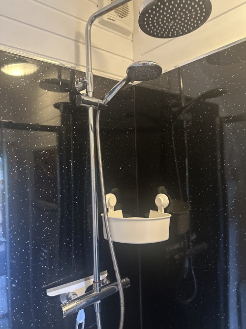 Modern shower enclosure with rainfall showerhead and handheld spray in Ladybird Pod at Acorns Luxury Glamping
