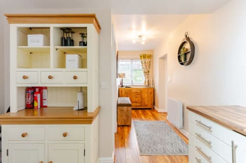 Modern kitchen with cream cabinetry and wooden counters at Acorns Luxury Glamping, Holywell