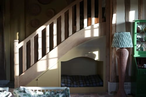 Chambre mansardée cosy sous un escalier en bois avec parure à carreaux à La Roquerie, villa rurale en Normandie