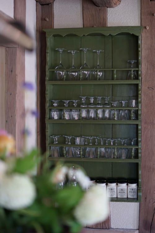 Étagère d'exposition en bois vert avec verrerie et pots à épices à la Ferme de La Roquerie, campagne française