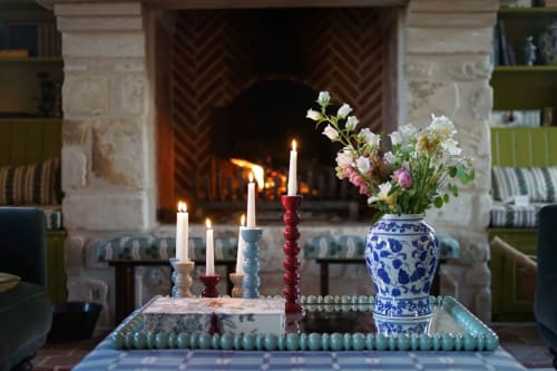Foyer élégant avec bougies et fleurs dans un vase bleu à la Ferme de la Roquerie