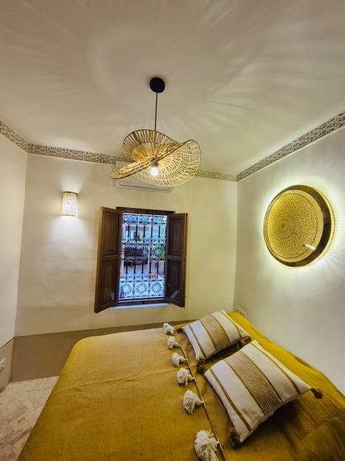 Chambre Stella Suite du Riad Casa Angelo à Marrakech avec lit jaune, suspension tissée et décoration murale