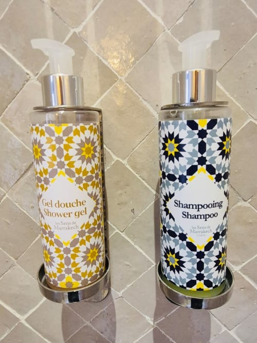 Deux flacons de salle de bain décorés de motifs géométriques islamiques au Riad Casa Angelo à Marrakech - gel douche et shampoing
