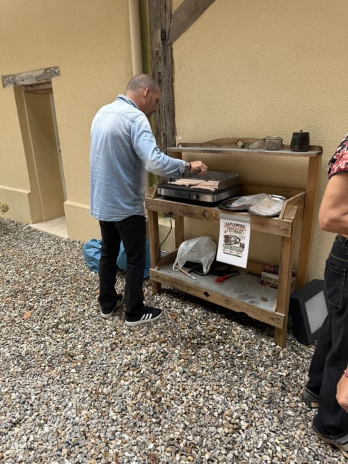 Homme préparant des mets à la station de gril en plein air aux Gîtes De Flaubert, Morville le Héron
