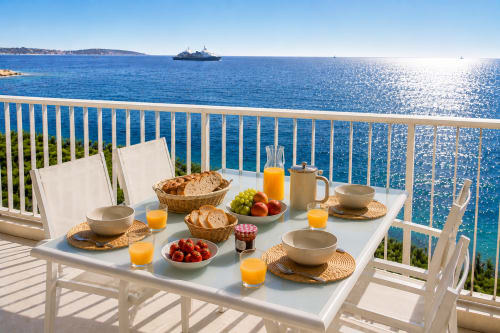 Petit-déjeuner en bord de mer sur un balcon face à la Méditerranée à Cannes avec vue sur un paquebot