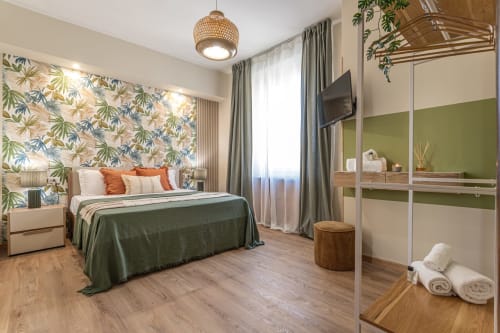 Camera da letto moderna a Terrestre Roma con carta da parati tropicale, dettagli verdi e vista sulla città vicino al Colosseo
