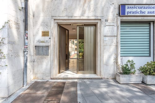 Ingresso alla boutique apartment Terrestre Roma per famiglie vicino al Colosseo, Roma con porte in vetro e entrata moderna