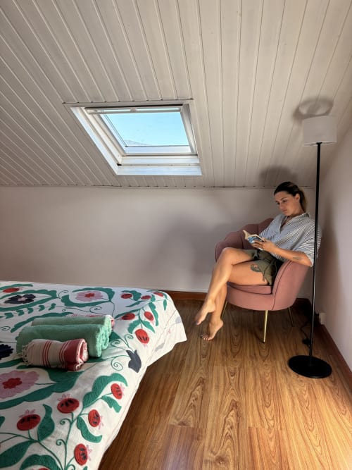 Woman relaxing in bedroom at La Villa Maraloupia villa, Les Avirons, with skylight and sea view