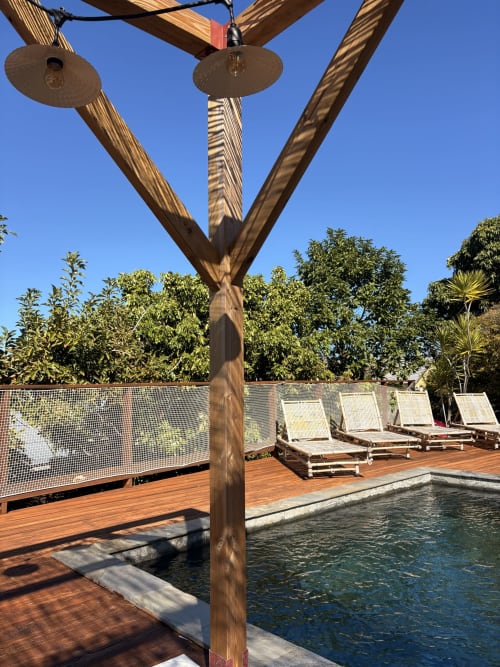 Wooden pergola with brass cymbals overlooking pool at La Villa Maraloupia, Les Avirons, Reunion Island