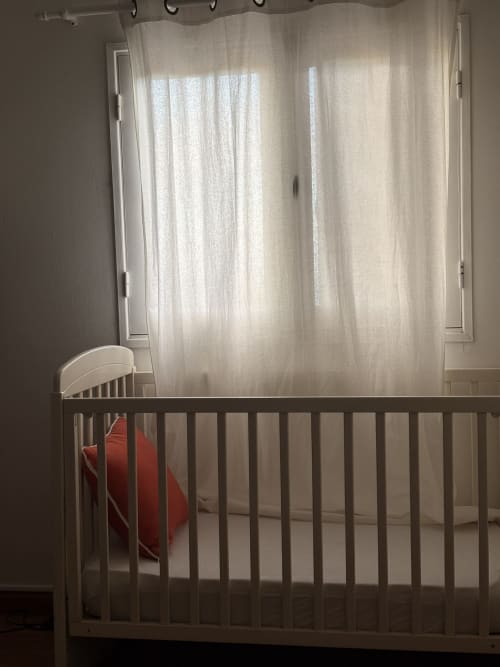 White crib with red bedding in bright nursery room at La Villa Maraloupia villa, Les Avirons