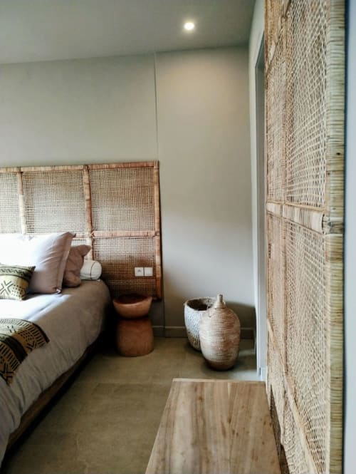 Chambre cosy à Nomads Togo Agbalapedogan à Lomé avec tête de lit en rotin, décoration tissée et vue sur le jardin