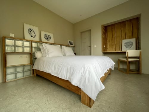 Chambre moderne à Nomads Togo avec lit en bois, draps blancs et vue sur le jardin à Lomé
