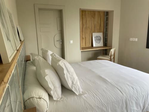 Chambre moderne à Nomads Togo Agbalepedogan à Lomé avec literie blanche, éléments en bois et vue sur le jardin