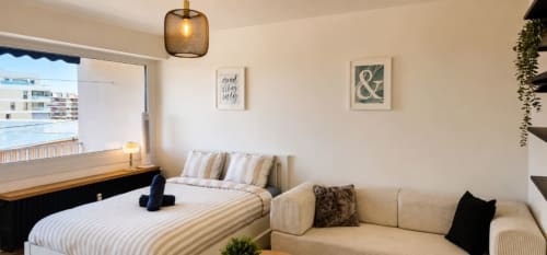 Chambre moderne au NN Patrimoine à Annemasse avec vue sur la ville, lit, canapé, suspension et accès balcon