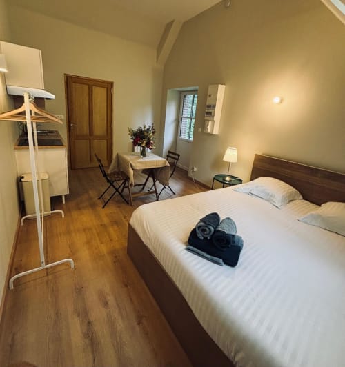 Studio confortable au Manoir De Daubeuf avec lit queen-size, parquet, bureau et éclairage chaleureux