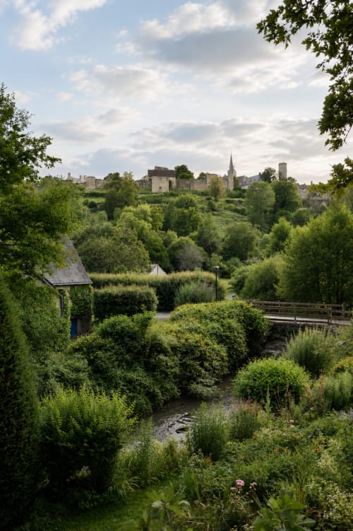 Ruines médiévales et clocher d'église dans la vallée de Sainte-Suzanne entourés d'une végétation verte luxuriante
