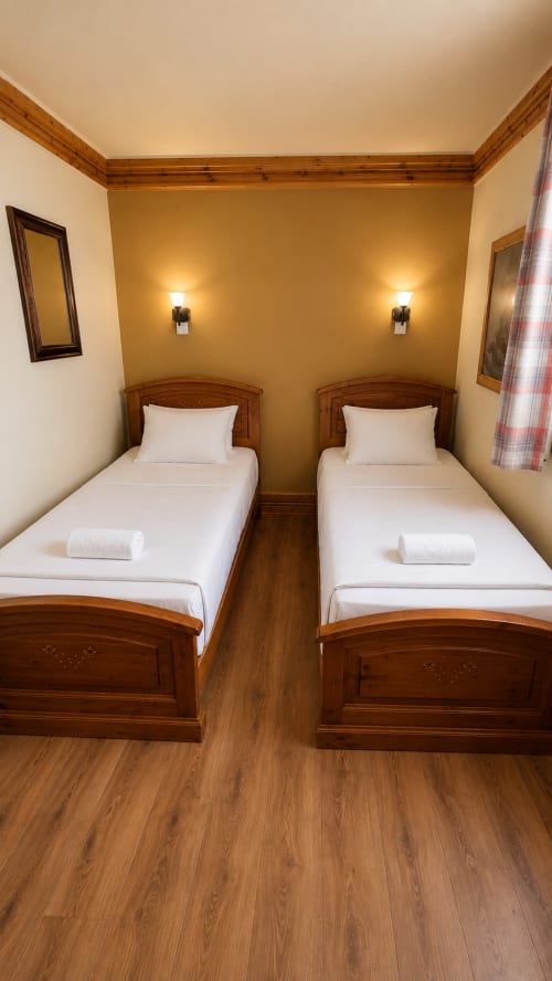 Chambre twin avec lits en bois et draps blancs au Chalet des Cimes, Belle Plagne