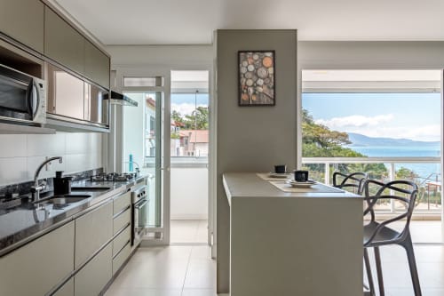 Cozinha moderna e área de refeições em apartamento à beira-mar com vista para o mar em Florianópolis, Brasil