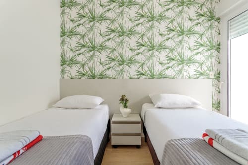 Quarto duplo com papel de parede botânico verde em apartamento à beira-mar de Canasvieiras, Florianópolis