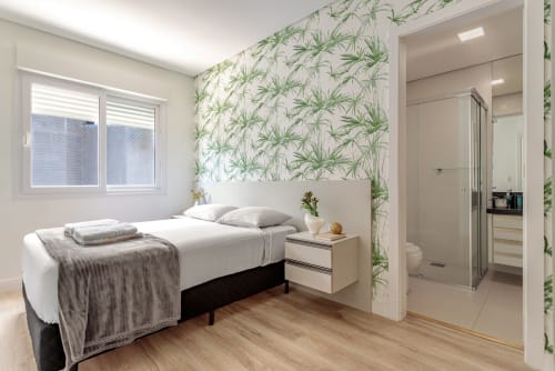 Quarto moderno em Canasvieiras com papel de parede botânico, piso de madeira, banheiro ensuite e vista para o mar
