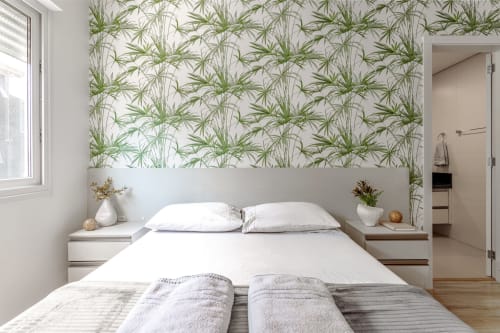 Quarto moderno com papel de parede de folhas tropicais, roupa de cama branca e vista para o mar na Villa Dell'Acqua em Florianópolis