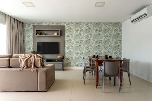 Apartamento moderno em Canasvieiras com sofá bege, mesa de jantar, papel de parede tropical, centro de entretenimento com TV e vista para o mar
