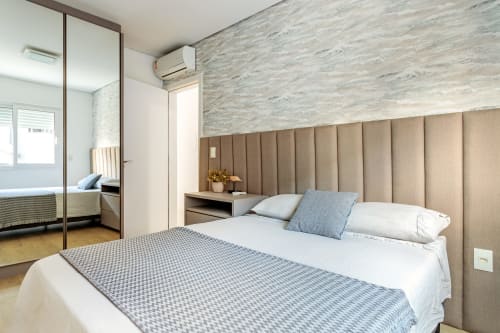 Quarto moderno de apartamento à beira-mar em Canasvieiras, Florianópolis com cabeceira estofada e vista para o mar