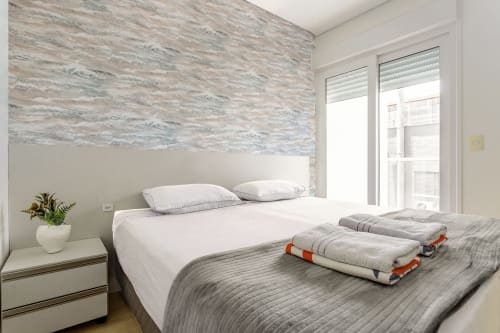 Quarto moderno de apartamento frente ao mar em Canasvieiras, Florianópolis com vista para o oceano, roupa de cama branca e design litorâneo contemporâneo