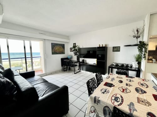 Intérieur moderne de l'appartement Barcaresa, Port-Leucate avec vue mer, table à manger, canapé noir, télévision écran plat et vue océan