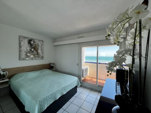 Chambre lumineuse avec literie turquoise, vue sur la mer et la piscine depuis le balcon à Barcaresa, Port Leucate
