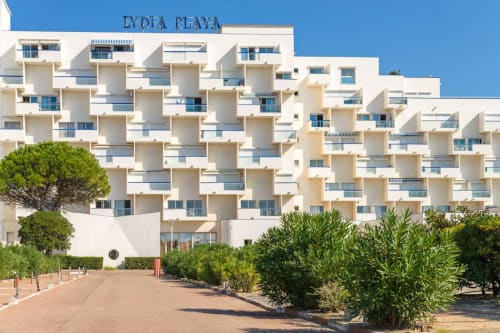 Hôtel Barcaresa à Port-Leucate avec balcons blanc échelonnés, vue sur mer et paysagisme méditerranéen sous ciel bleu dégagé